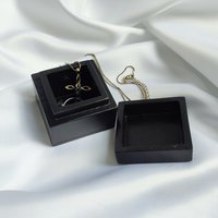 Small black trinket box with silver sun plaque on lid.