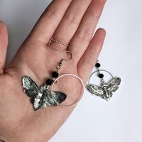 Silver death mask earrings with metal ring and black crystal beads.