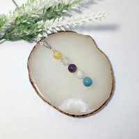 Depression pendant with citrine, rose quartz, amethyst, moonstone, aquamarine and chain or cord.