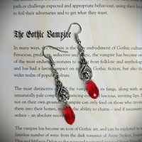 Gothic vampire bat earrings with red or black bead drops.