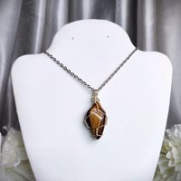 Tiger's eye wire wrapped pendant with chain or cord.