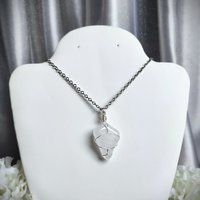 Clear quartz pendant wrapped in silver plated wire with chain or cord.