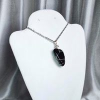 Obsidian wire wrapped pendant in silver with chain or cord.