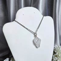 Clear quartz pendant wrapped in silver plated wire with chain or cord.