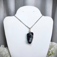 Obsidian wire wrapped pendant in silver with chain or cord.