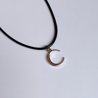 Silver crescent moon choker necklace on black cord.