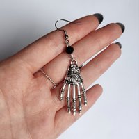 Pair of silver skeleton hand earrings.