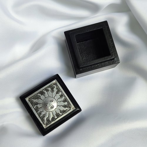 Small black trinket box with silver sun plaque on lid.