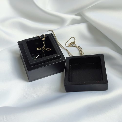 Small black trinket box with silver sun plaque on lid.