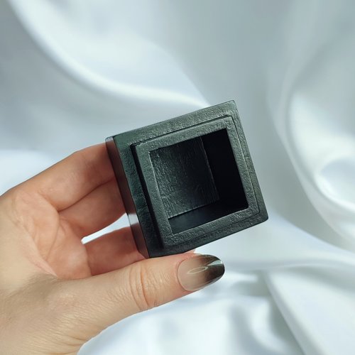 Small black trinket box with silver sun plaque on lid.