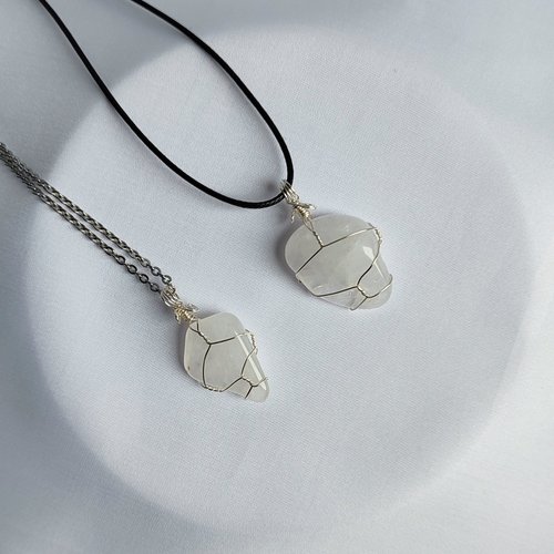 Clear quartz pendant wrapped in silver plated wire with chain or cord.