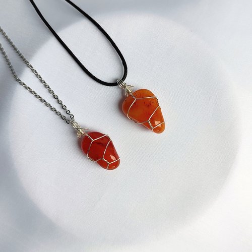 Carnelian pendant wrapped in silver plated wire with chain or cord.