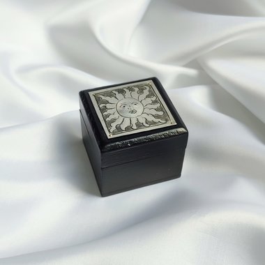Small black trinket box with silver sun plaque on lid.