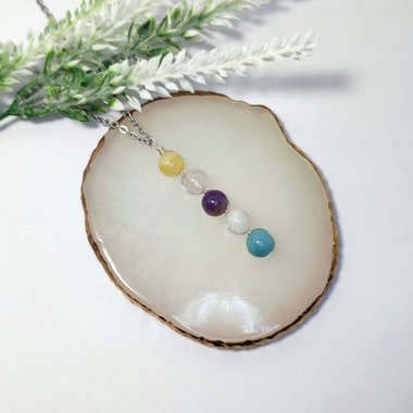 Depression pendant with citrine, rose quartz, amethyst, moonstone, aquamarine and chain or cord.