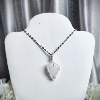 Clear quartz pendant wrapped in silver plated wire with chain or cord.