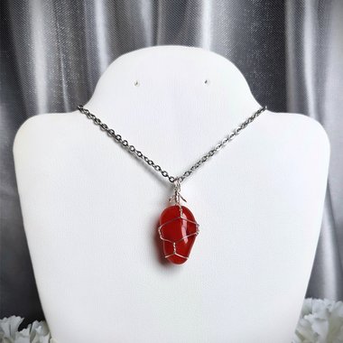 Carnelian pendant wrapped in silver plated wire with chain or cord.